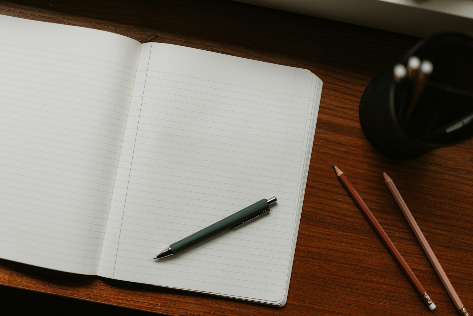 Un carnet et un stylo posés sur un bureau en bois